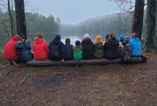 inimesed istuvad reas palgil ja vaatavad järvele